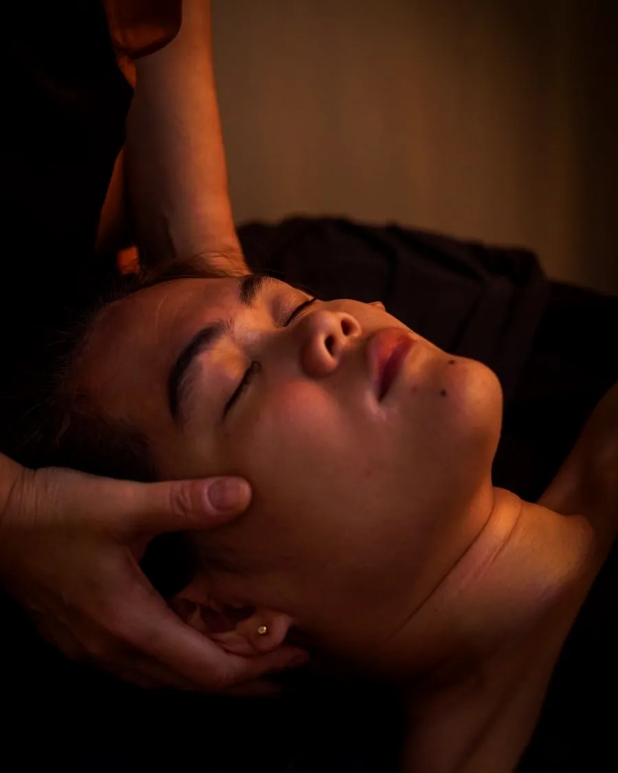 Soin du visage : mains en coque qui enveloppent le crâne, détente profonde.